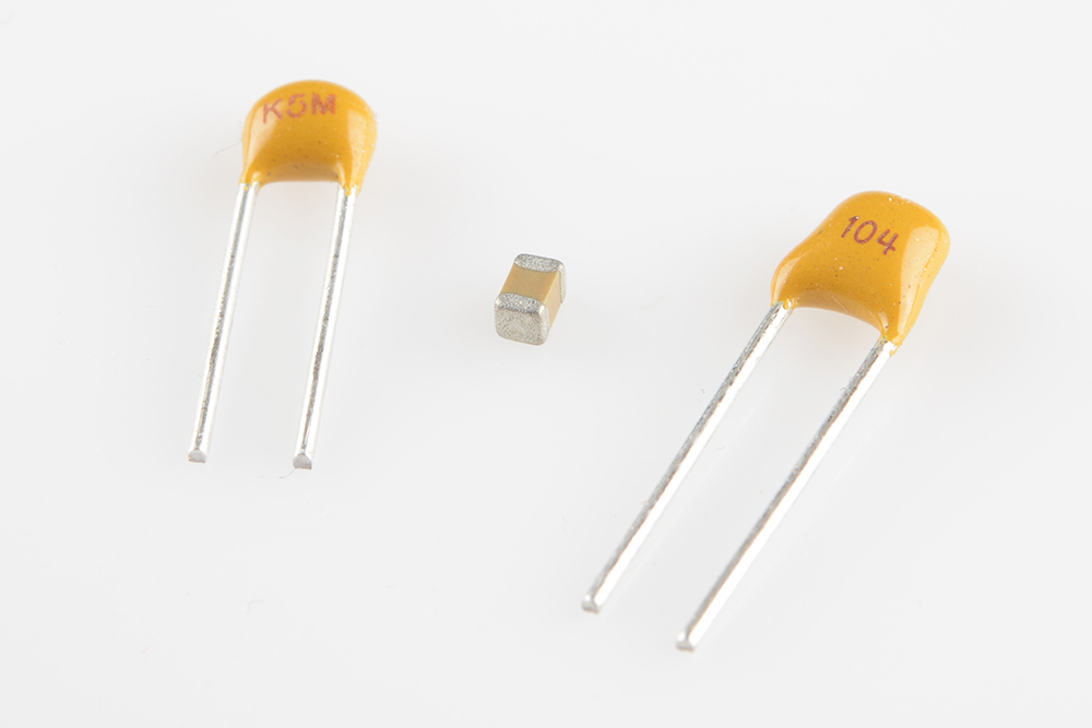 スルーホールタイプのラジアルパッケージのコンデンサ2個。左が22pF、右が0.1µF。中央は0.1µFの小さな0603サイズの表面実装コンデンサ