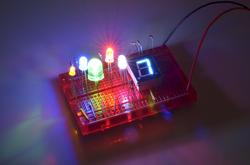 さまざまなスルーホール型LED。左から黄色3mm、青色5mm、緑色10mm、超高輝度赤色5mm、RGB 5mm、青色7セグメントLED
